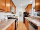 Well-lit kitchen features stone countertops, stainless steel appliances, and wood cabinetry at 4201 Shoshone St, Denver, CO 80211