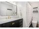 Modern bathroom featuring gold hardware, a black vanity and a pristine white toilet at 1020 Kalamath St, Denver, CO 80204