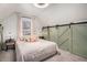 Comfortable bedroom featuring an accent wall with sliding barn doors, soft natural lighting, and plush carpeting at 1020 Kalamath St, Denver, CO 80204