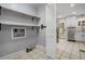 Laundry room with open shelving, tile flooring, next to the kitchen with stainless steel appliances at 1020 Kalamath St, Denver, CO 80204