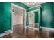 Living room showcasing dark green walls, with open doorway and mirror closet doors at 1020 Kalamath St, Denver, CO 80204