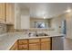 Spacious kitchen with stainless steel appliances, light wood cabinets, and views of the living area at 1016 Opal St # 102, Broomfield, CO 80020