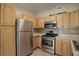 Well-appointed kitchen featuring stainless steel appliances, light wood cabinets, and decorative backsplash at 1016 Opal St # 102, Broomfield, CO 80020