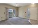 Carpeted living room with sliding glass doors, neutral paint, ceiling fan, and access to outdoor space at 1016 Opal St # 102, Broomfield, CO 80020