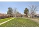Expansive backyard with lush lawn, mature trees, and a charming garden space, offering endless possibilities for outdoor enjoyment at 1480 S Osceola St, Denver, CO 80219