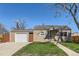 Charming single-story home with a well-maintained lawn, attached garage and inviting entrance at 1480 S Osceola St, Denver, CO 80219