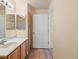 Bathroom with a double vanity, mirror, and a view of a door and an additional doorway at 4747 S Balsam Way # 104, Littleton, CO 80123