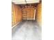 Spacious unfinished garage interior featuring a concrete floor, plywood walls, and ample storage shelving at 4747 S Balsam Way # 104, Littleton, CO 80123