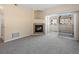 Living room showcasing a charming fireplace, sliding glass doors to the outdoor patio, and neutral carpet at 4747 S Balsam Way # 104, Littleton, CO 80123