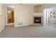 Living room showcasing a charming fireplace, sliding glass doors to the outdoor patio, and neutral carpet at 4747 S Balsam Way # 104, Littleton, CO 80123