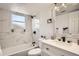 Well-lit bathroom featuring a marble-walled tub, shower, and updated vanity at 17979 E Oxford Pl, Aurora, CO 80013