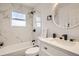 Modern bathroom with marble tile, a sleek vanity, and a window for natural light at 17979 E Oxford Pl, Aurora, CO 80013