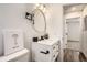Stylish half bath with updated vanity, faucet, and modern round mirror at 17979 E Oxford Pl, Aurora, CO 80013