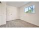 Bright, airy bedroom with new carpet, a window overlooking the trees, and a white paneled door at 17979 E Oxford Pl, Aurora, CO 80013