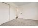 Bright bedroom with neutral carpet, large closet, and white walls at 17979 E Oxford Pl, Aurora, CO 80013
