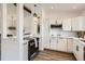 Modern kitchen with white cabinets, stainless steel appliances, and a view of the open living space at 17979 E Oxford Pl, Aurora, CO 80013