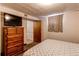 Cozy bedroom featuring dresser with TV, window and view into the en suite bathroom at 2785 Skyline Dr, Westminster, CO 80030