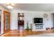 Open concept living room with hardwood floors, tv, and door leading to the kitchen at 2785 Skyline Dr, Westminster, CO 80030