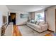 Comfortable living room featuring a plush sofa, hardwood floors, and large window with natural light at 2785 Skyline Dr, Westminster, CO 80030