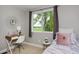 Cozy bedroom with a desk area, a bed with a pink blanket, and a lovely window view at 236 W Sycamore Ln, Louisville, CO 80027