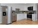 Modern kitchen with stainless steel appliances, sleek cabinetry, stylish backsplash, and hardwood floors at 236 W Sycamore Ln, Louisville, CO 80027