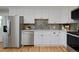 Modern kitchen with stainless steel appliances, white cabinets, quartz counters, and tile backsplash at 236 W Sycamore Ln, Louisville, CO 80027