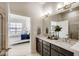 Bathroom featuring double vanity with stone countertop, tile floors and walk-in shower visible in mirror at 917 W 129Th Pl, Denver, CO 80234