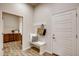 Hallway with laundry room and coat rack featuring a white bench and neutral accents at 917 W 129Th Pl, Denver, CO 80234