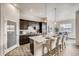Modern kitchen with dark cabinets, white countertops, stainless steel appliances, and dining area at 917 W 129Th Pl, Denver, CO 80234