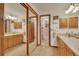 A bathroom boasting double sinks, wood framed mirrors and cupboards, with access to storage at 2038 S Hoyt Way, Lakewood, CO 80227