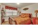 Warm bedroom featuring red and gold bedding, a window with blinds, and decorative accents at 2038 S Hoyt Way, Lakewood, CO 80227