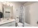 Bathroom with patterned shower curtain features a white sink and toilet at 6664 Merrimack Dr, Castle Pines, CO 80108