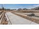 Scenic view of a well-maintained community with a paved pathway winding through natural landscape at 6664 Merrimack Dr, Castle Pines, CO 80108