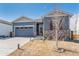 Attractive single-story home with gray siding, stone accents, and a two-car garage at 6664 Merrimack Dr, Castle Pines, CO 80108