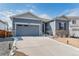 Charming single-story home with a gray siding, stone accents, and attached two-car garage at 6664 Merrimack Dr, Castle Pines, CO 80108