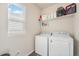 Bright laundry room featuring a modern washer, dryer, and ample storage on a shelf at 6664 Merrimack Dr, Castle Pines, CO 80108