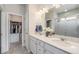 Well-lit main bathroom with double sinks, quartz countertop, and a walk-in closet at 6664 Merrimack Dr, Castle Pines, CO 80108
