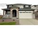 Charming two-story home with stone accents, covered porch, and a white garage door at 687 Raindance St, Erie, CO 80516
