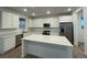 Bright, modern kitchen with stainless steel appliances, quartz countertops, and a large center island at 687 Raindance St, Erie, CO 80516
