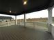 Covered patio with wood flooring and white pillars overlooks a spacious backyard at 687 Raindance St, Erie, CO 80516