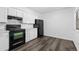 Cozy kitchen with white cabinets, black appliances, and wood-style floors creating a clean and functional space at 7220 S Gaylord St # G17, Littleton, CO 80122