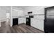 Bright kitchen featuring white cabinetry, black appliances, and gray wood flooring offering a modern aesthetic at 7220 S Gaylord St # G17, Littleton, CO 80122