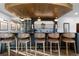 Custom bar with wine storage, pendant lighting, and comfortable seating, perfect for entertaining guests in style at 948 Buffalo Ridge Rd, Castle Pines, CO 80108