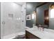 Elegant bathroom features a glass shower, green textured walls, and a dark wood vanity with a marble countertop at 948 Buffalo Ridge Rd, Castle Pines, CO 80108