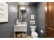 Chic powder room features a marble sink, dark gray walls, modern fixtures, and neutral décor at 948 Buffalo Ridge Rd, Castle Pines, CO 80108