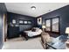 Stylish bedroom with navy walls features a dark wood bed frame and shuttered windows for a modern aesthetic at 948 Buffalo Ridge Rd, Castle Pines, CO 80108
