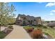 Charming home exterior with a well-manicured lawn, mature trees, and a welcoming driveway, showcasing curb appeal at 948 Buffalo Ridge Rd, Castle Pines, CO 80108