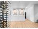 Hallway featuring a wine cellar, light hardwood floors, white walls and trim, and sconces for a luxurious aesthetic at 948 Buffalo Ridge Rd, Castle Pines, CO 80108