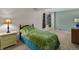 Bedroom featuring a bed with green covers, a window with blinds, and a nightstand at 5660 S Eaton St, Littleton, CO 80123