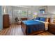Bedroom with wood floors, blue bedding, and sunny window at 5660 S Eaton St, Littleton, CO 80123